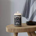 Candle with a cat design and text on a wooden table