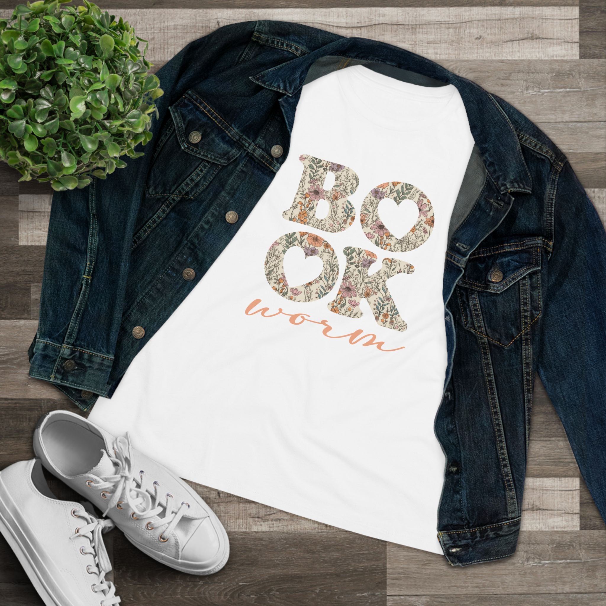 T-shirt with 'Bookworm' design, denim jacket, and white sneakers on a wooden surface.