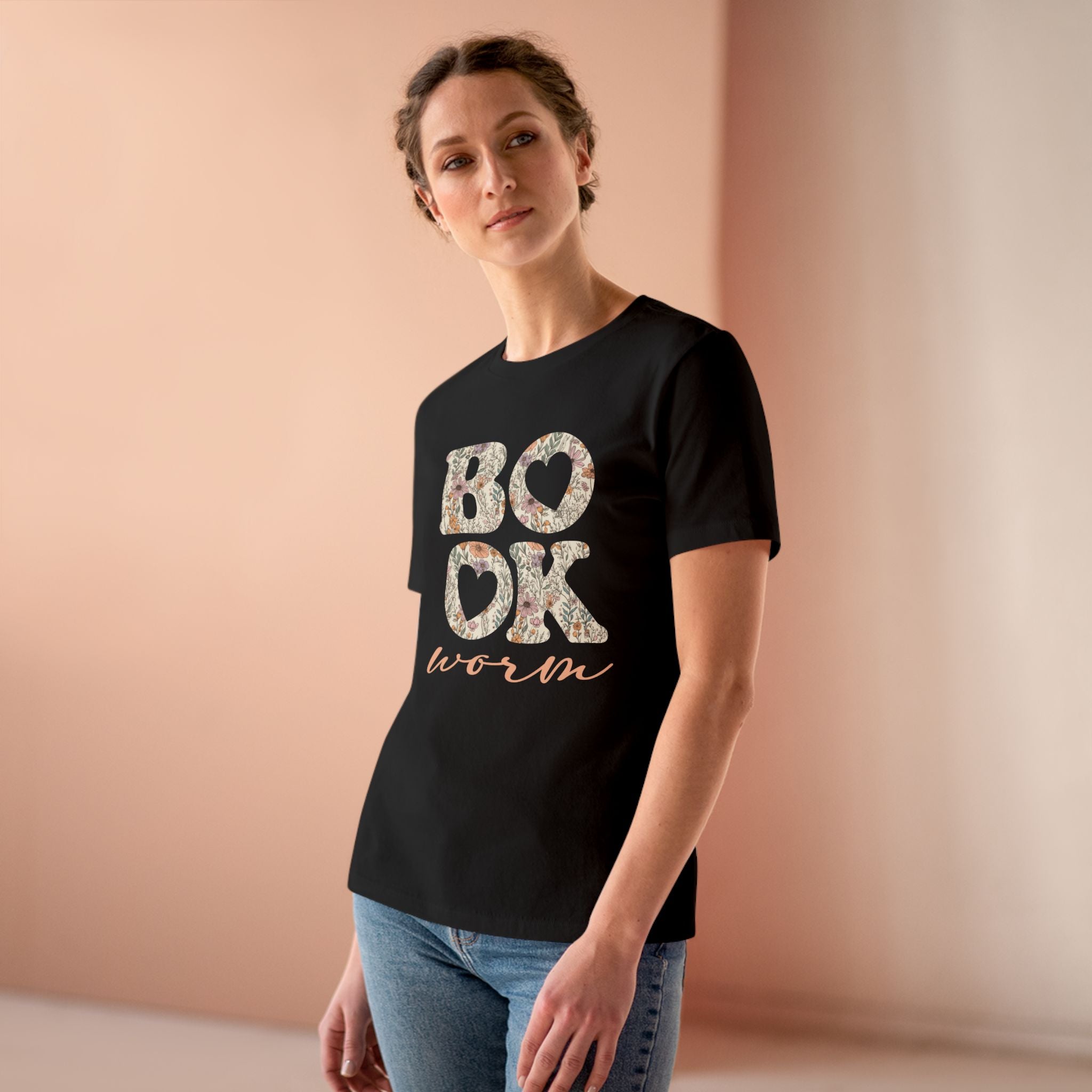 Woman wearing a black t-shirt with 'BOOKworm' text against a beige background