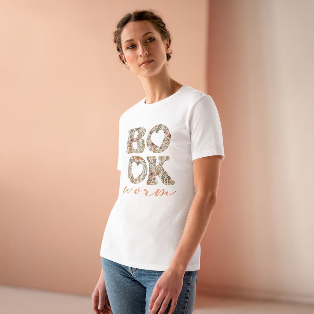 Woman wearing a white t-shirt with floral text design against a beige background