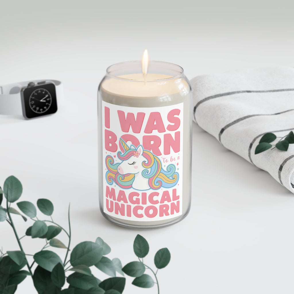 Candle with a unicorn-themed label on a white surface with a plant and watch in the background