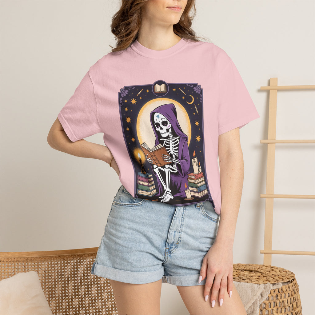Person wearing a pink t-shirt with a graphic design of a skeleton and books.