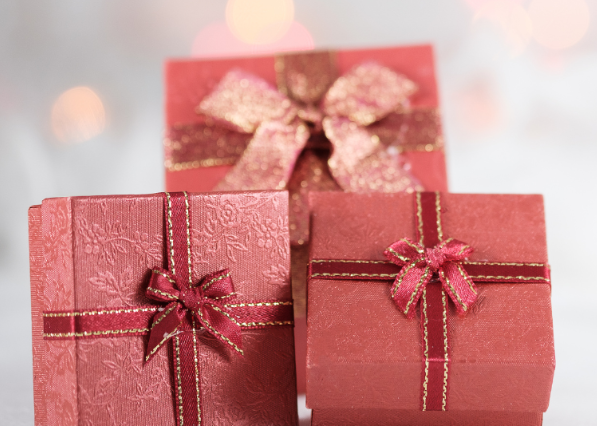 Red gift boxes with ribbons on a blurred background with 'Gift Shop' text and snowflake icon.
